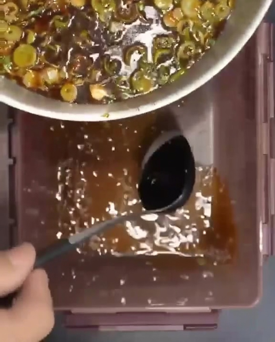Costine di manzo crude disposte in un contenitore con la marinata versata sopra.