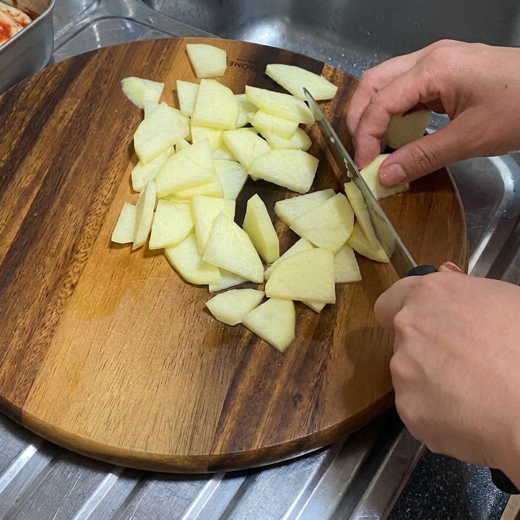 Una cipolla tagliata a spicchi spessi su un tagliere di legno.