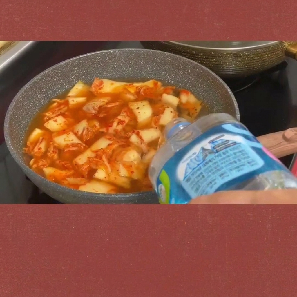 Fette di spam aggiunte allo stufato di kimchi gorgogliante.