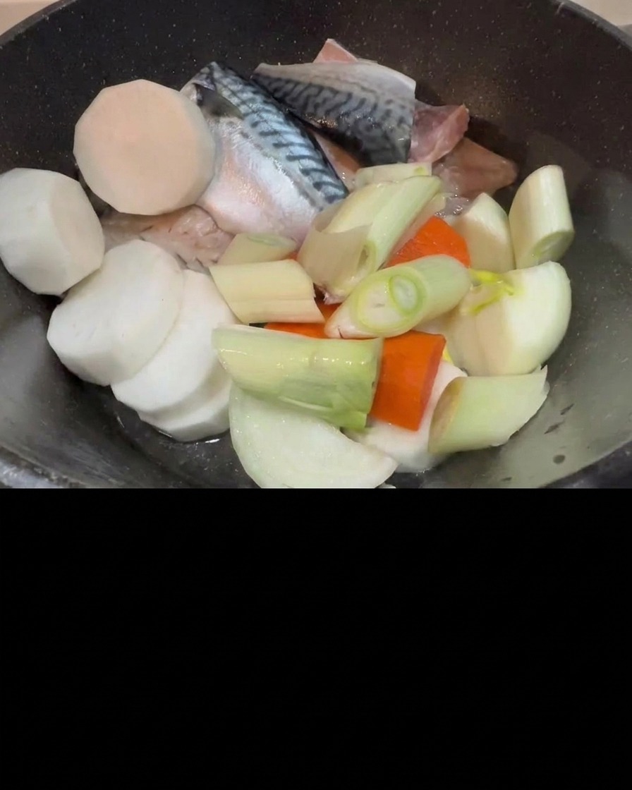 Kimchi che viene aggiunto nella pentola con sgombro crudo, ravanello e cipollotti.