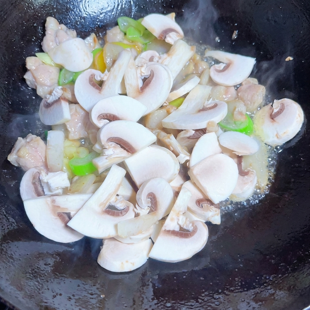 Una miscela di funghi affettati, cipolle e germogli di soia saltati in padella con le spezie.