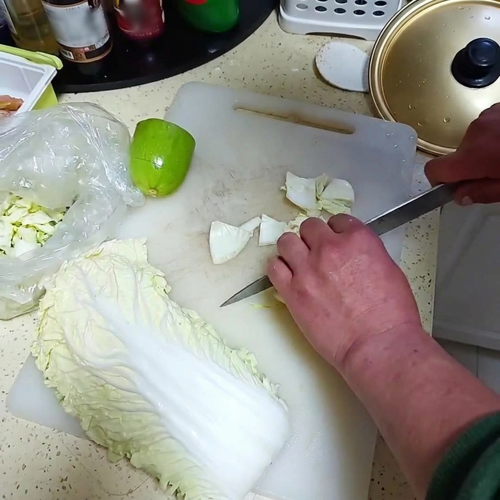 Cipolla fresca e un piccolo melone verde tagliati a pezzi su un tagliere bianco.