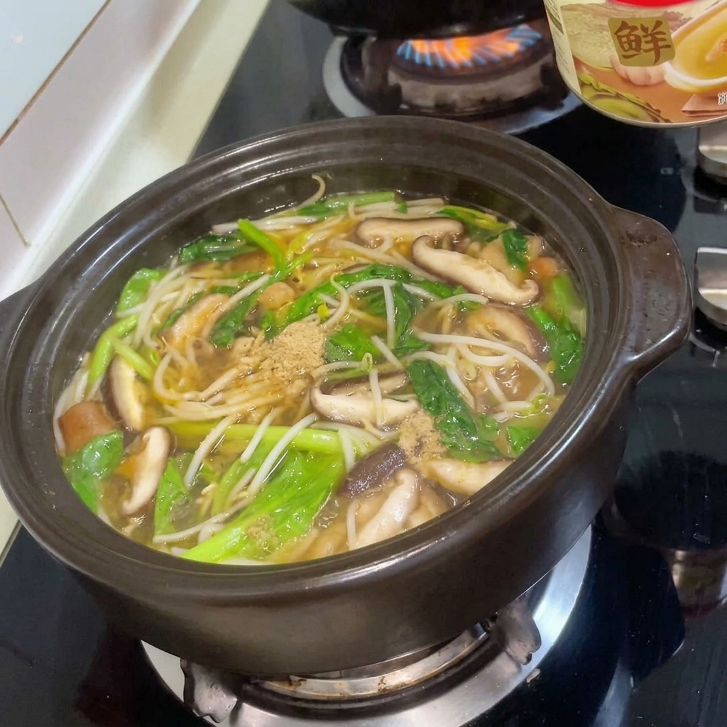 Preparato per brodo di carne spolverato nello stufato bollente nel tegame di terracotta.
