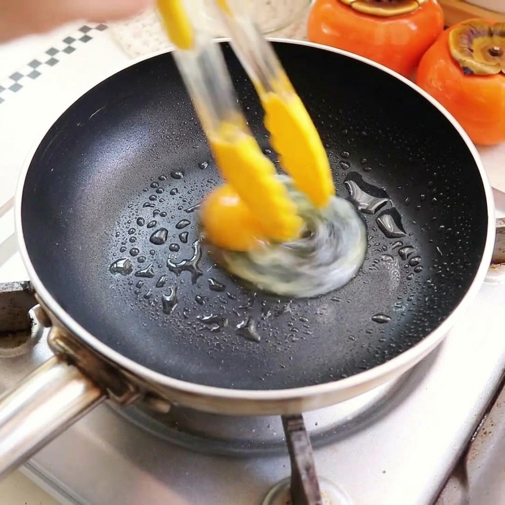 Uova che friggono in una padella con olio caldo.