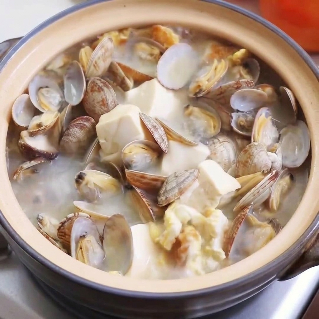 Vista ravvicinata di brodo di pollo, sale e pepe aggiunti alla zuppa.