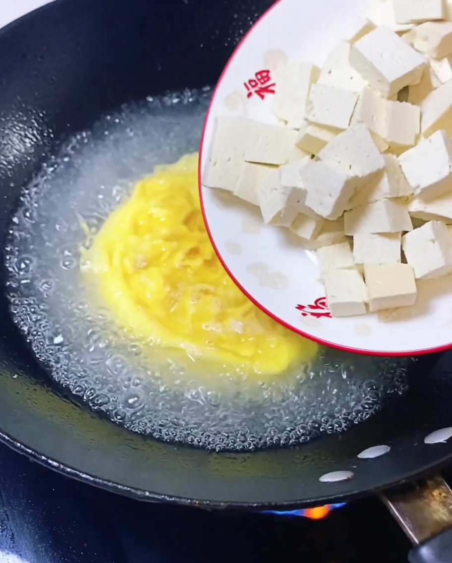 Cubetti di tofu aggiunti al brodo in ebollizione.