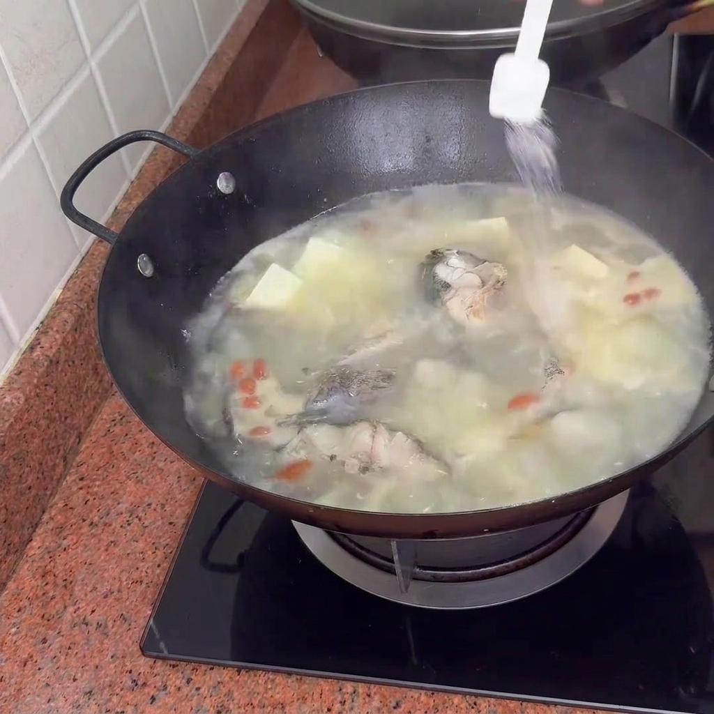 Condimenti aggiunti alla zuppa mentre sobbolle con tofu e bacche di goji.