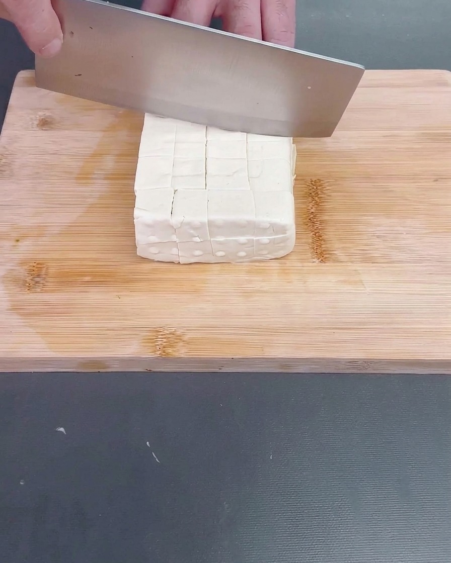 Una luffa fresca sbucciata tagliata a pezzi irregolari di dimensioni adatte a un boccone.