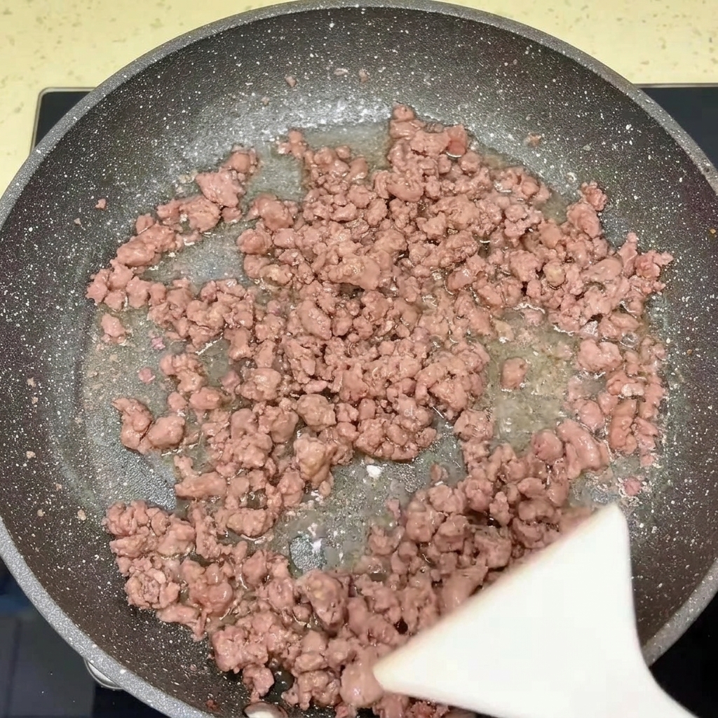 Una padella contenente manzo e cipolle cotte.