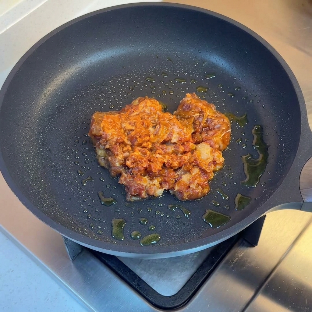 Carne macinata saltata in padella con cipolle, peperoni verdi e peperoncino rosso a cubetti.
