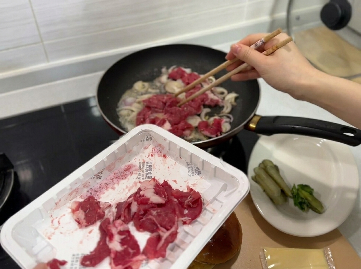 Sottili fette di manzo crudo fresco aggiunte alla padella con le cipolle saltate.