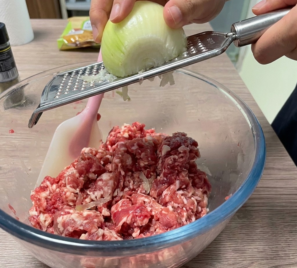 Cipolla grattugiata aggiunta direttamente nella ciotola della carne.