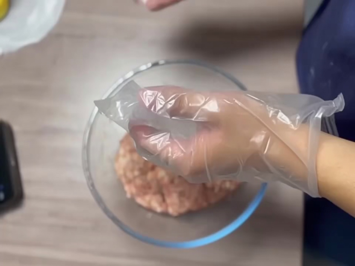 Mani con guanti che formano una palla di carne liscia.