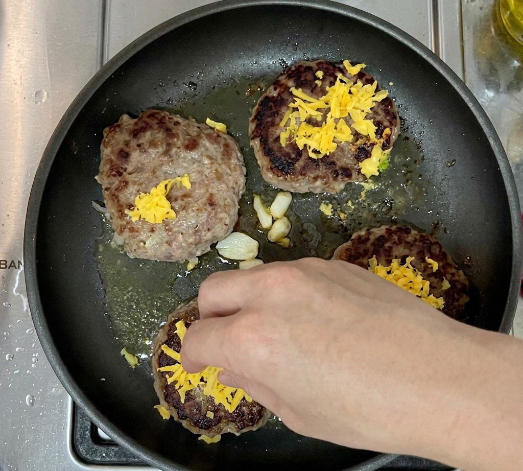 Polpette in cottura guarnite con cheddar.