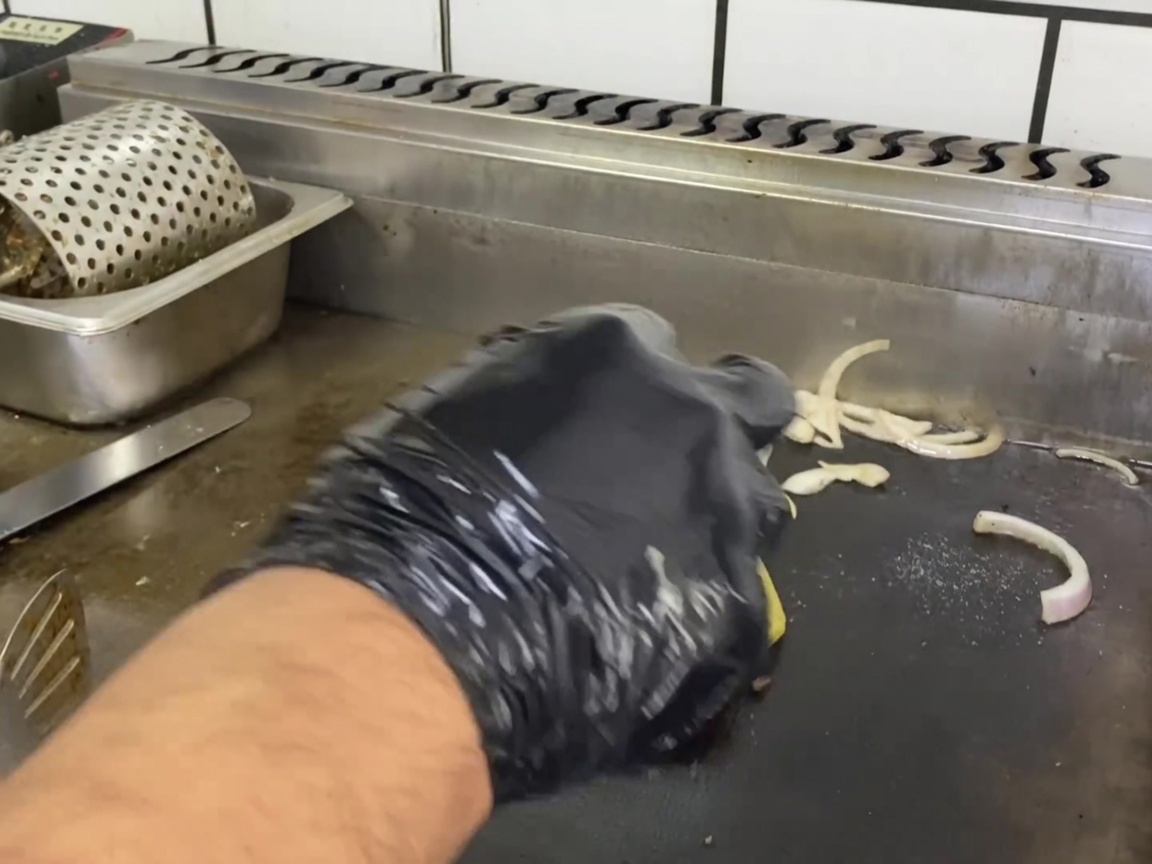 Un hamburger rosolato con una fetta di formaggio che si scioglie sopra.