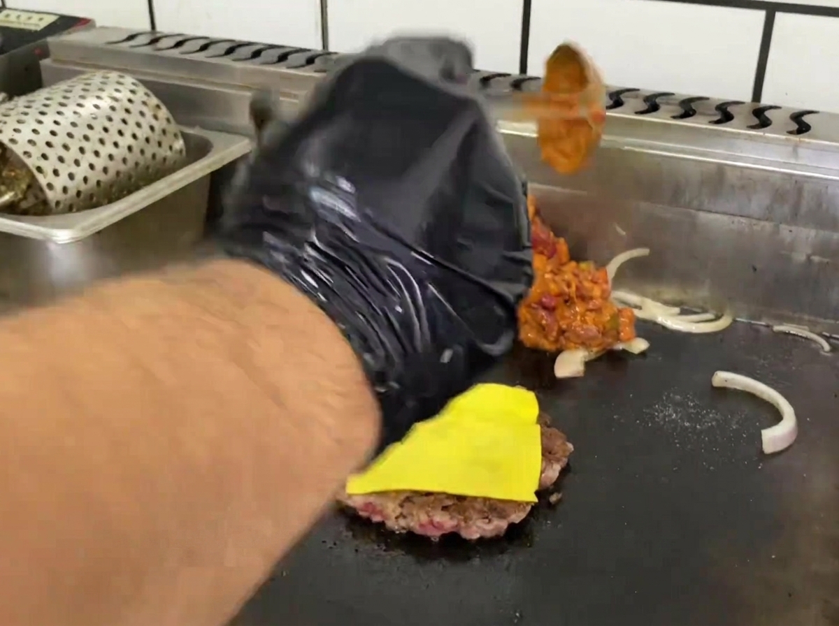 Salsa chili di manzo che si scalda sulla piastra accanto allhamburger.