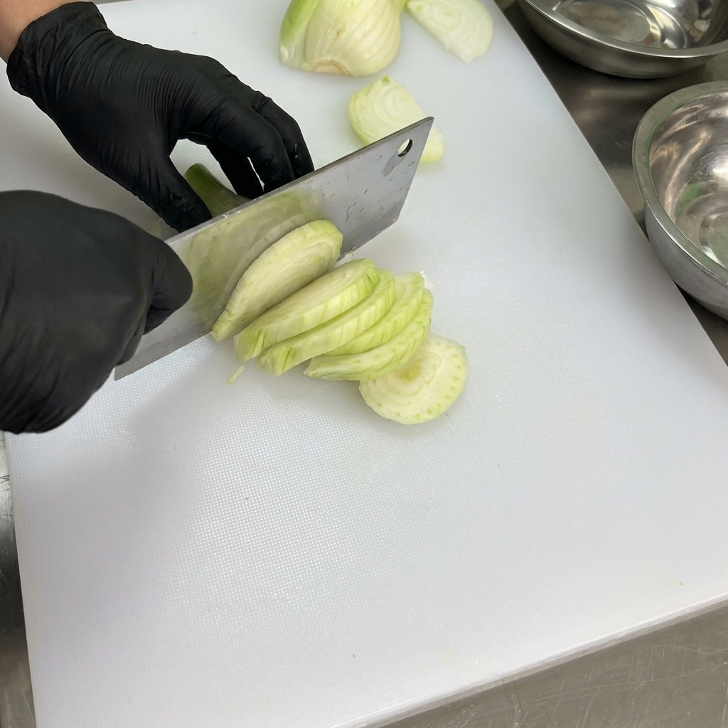 Peperoni freschi puliti e privati dei semi su un tagliere bianco.