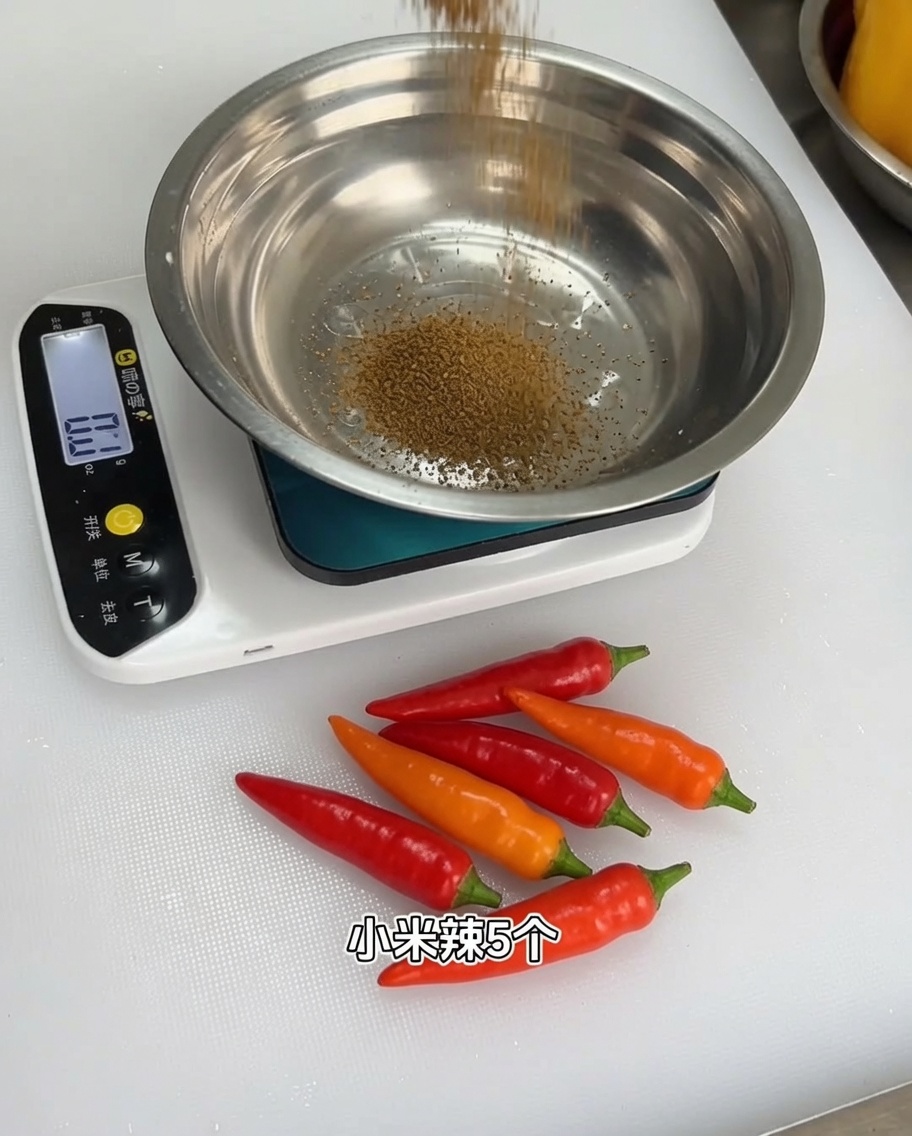 Un mix di spezie aromatiche misurate in una ciotola di metallo su una bilancia digitale.