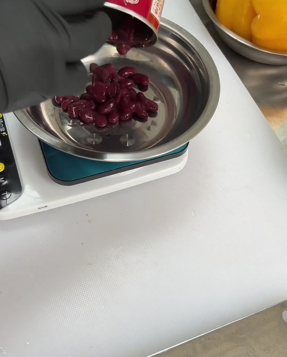 Fagioli rossi aggiunti alla ciotola con spezie e peperoncini.