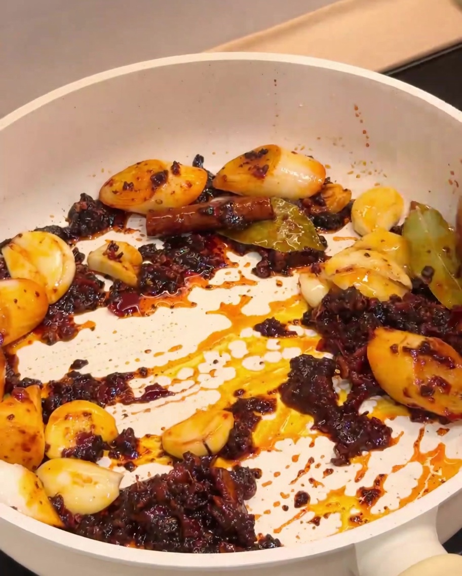 Gamberi fritti mescolati con la base di spezie aromatiche in padella.