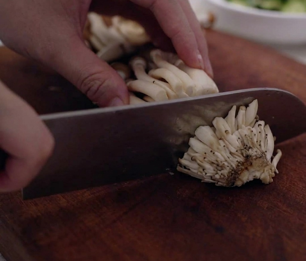 Grappoli di funghi shimeji puliti e separati su un tagliere.