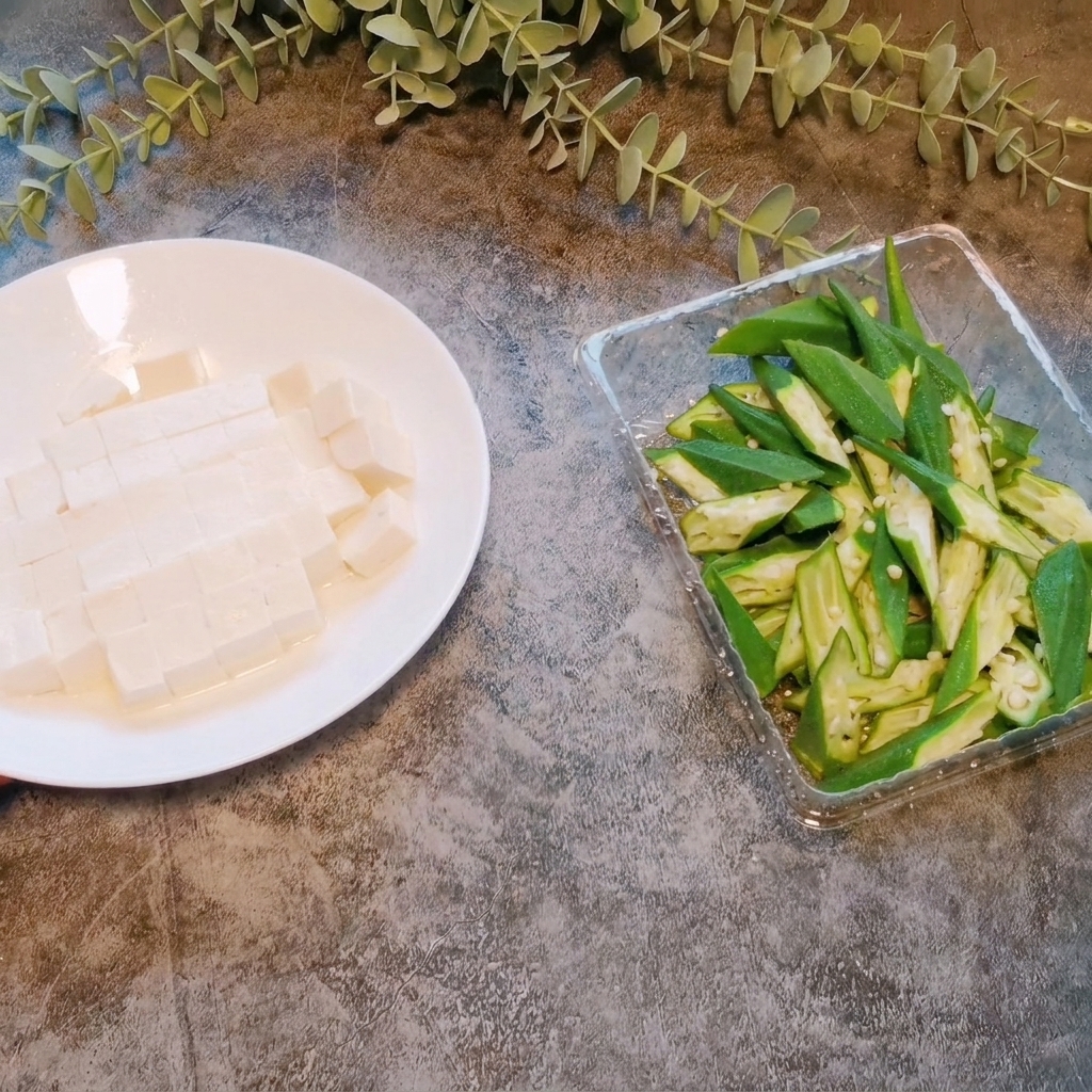 Un panetto di tofu morbido tagliato in piccoli cubetti uniformi su un piatto bianco.