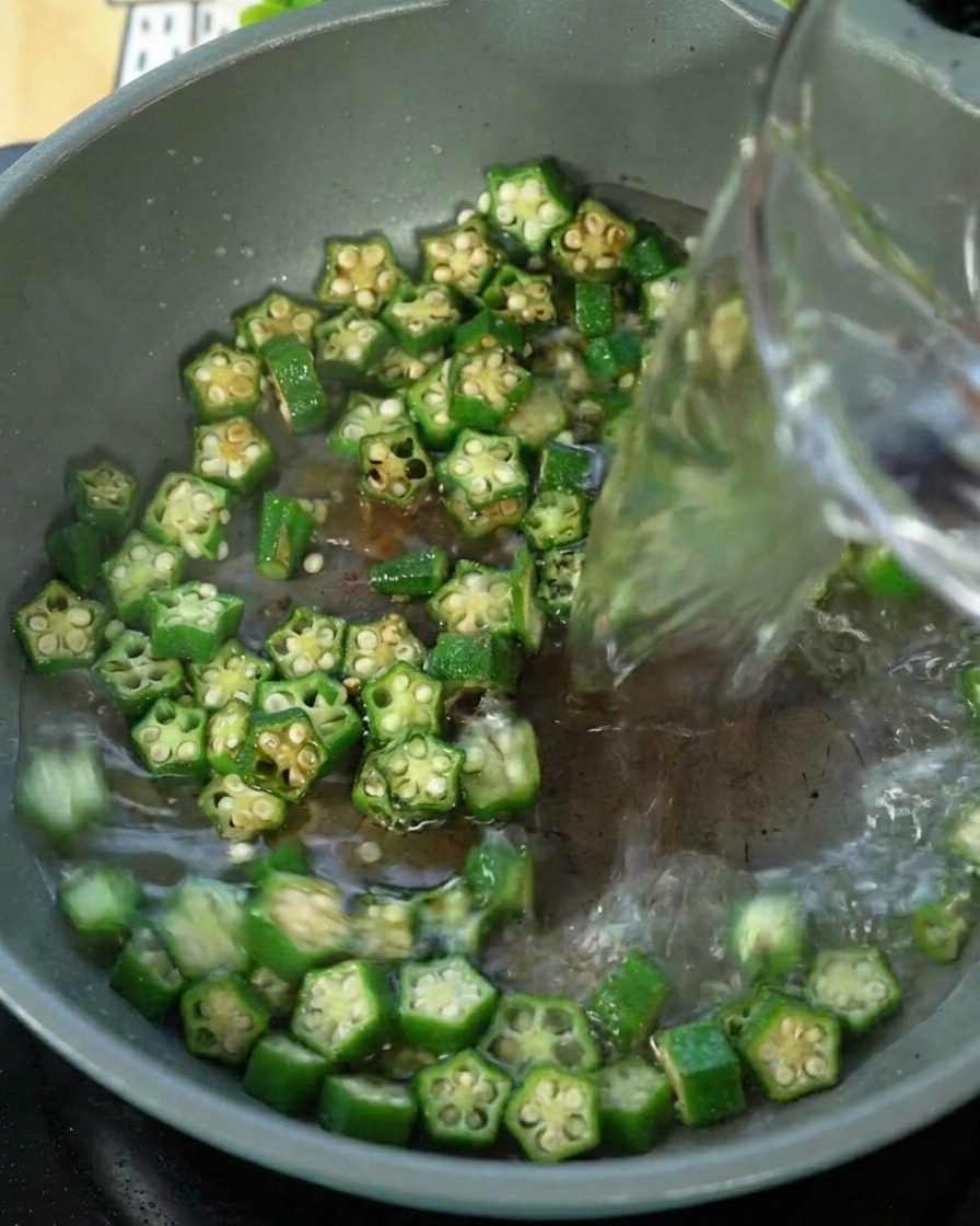 Acqua versata in una padella contenente lokra saltata.