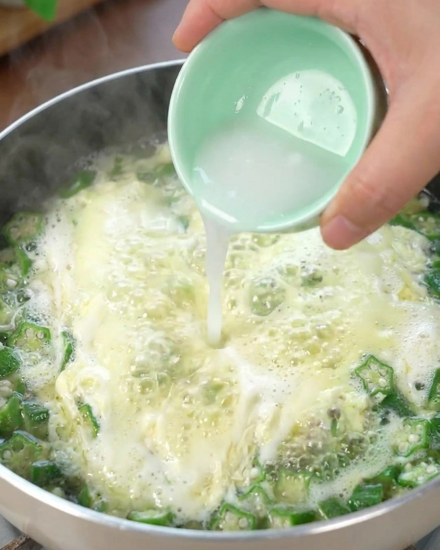 Acqua e fecola versate nella zuppa di okra e uova, addensando il brodo.