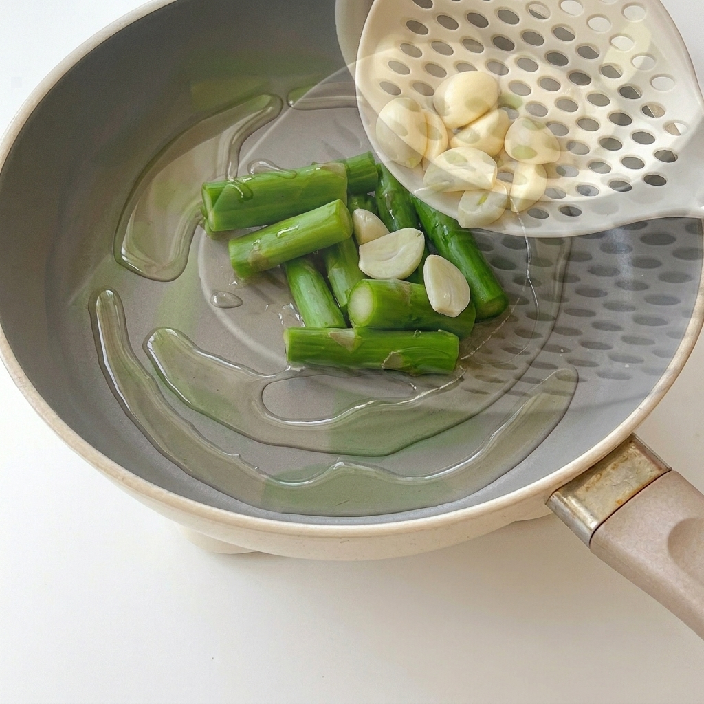 Metà di spicchi daglio che soffriggono in padella con olio caldo.