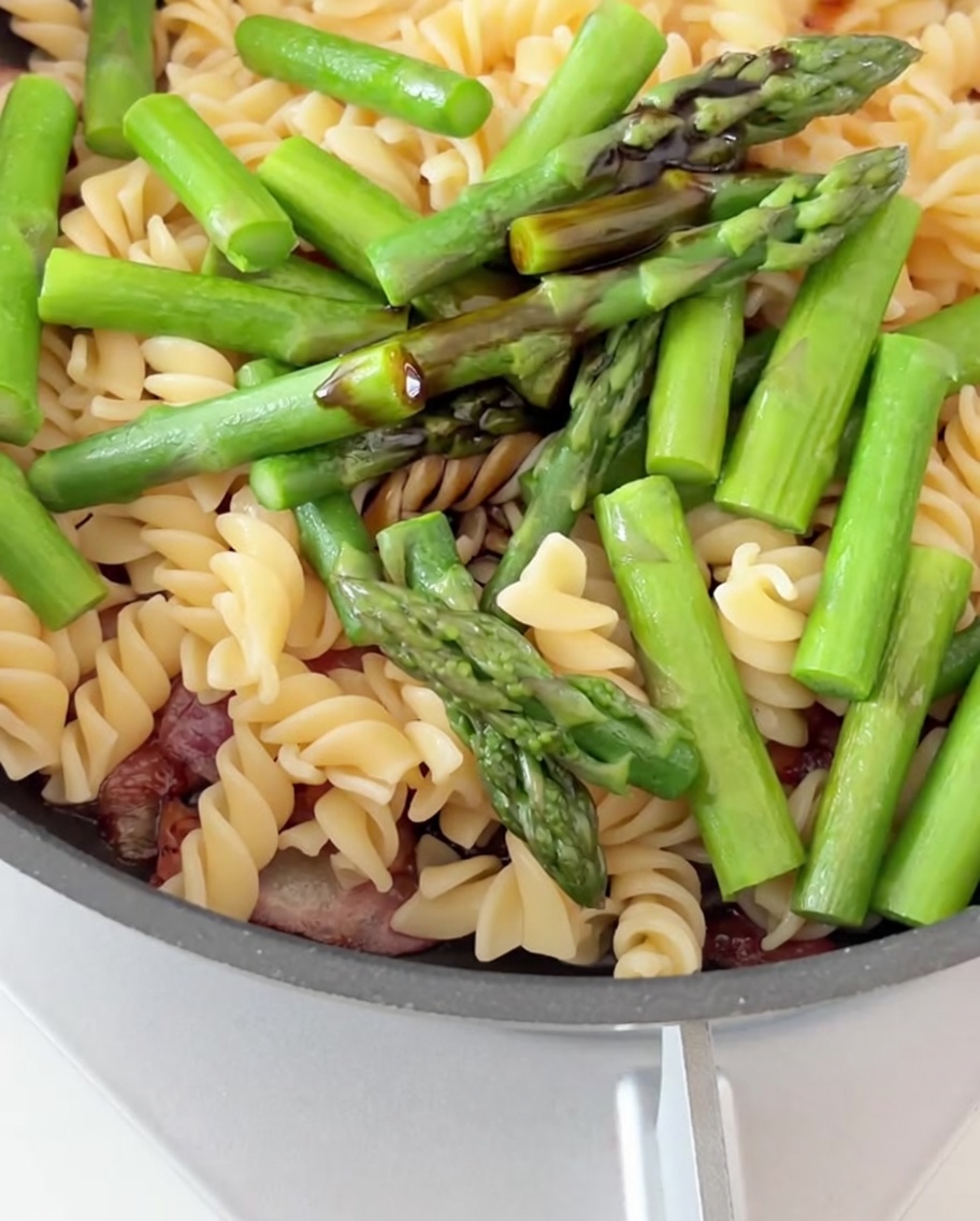 Salsa di soia e di ostriche versate sulla pasta, pancetta e asparagi.
