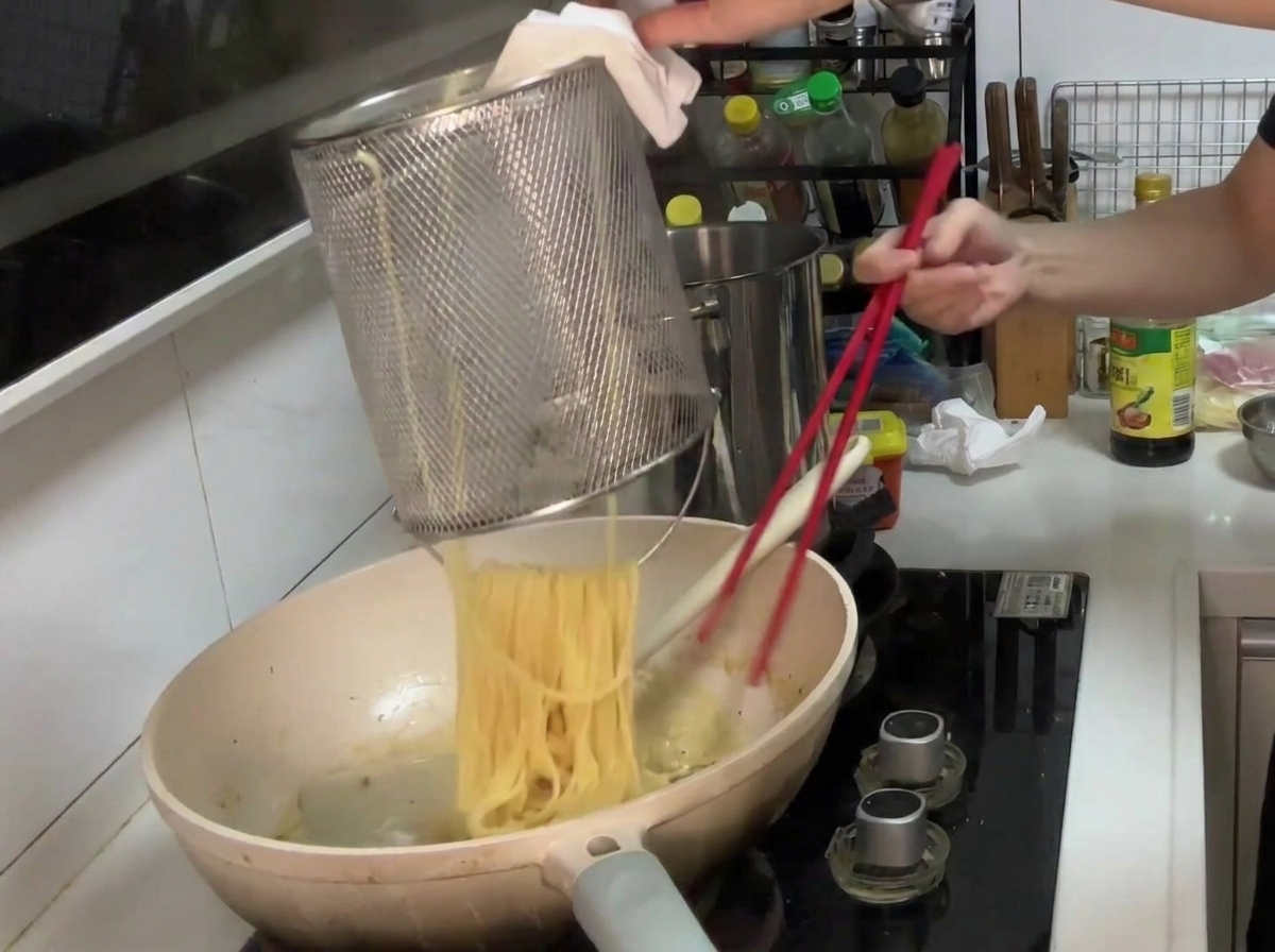 Pasta trasferita in padella con la salsa cremosa pronta per essere mantecata.
