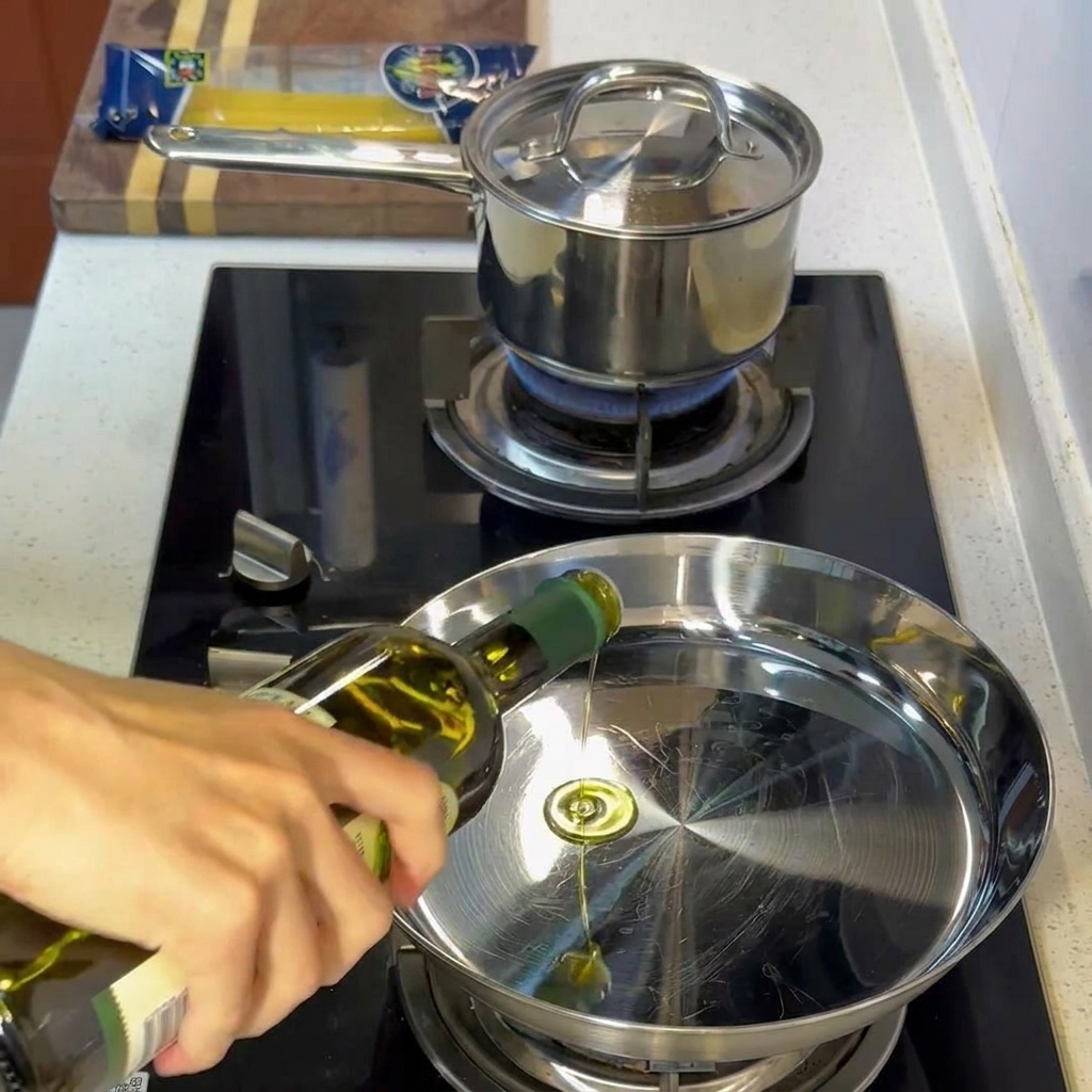 Olio doliva che sfrigola in una padella in acciaio inossidabile calda.