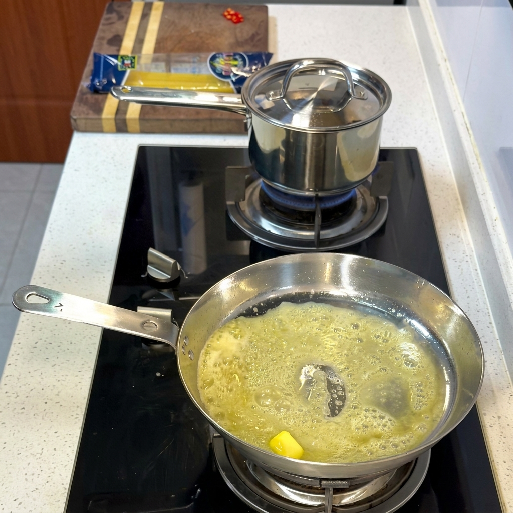 Gamberi e capesante che cuociono nel composto di burro e olio.