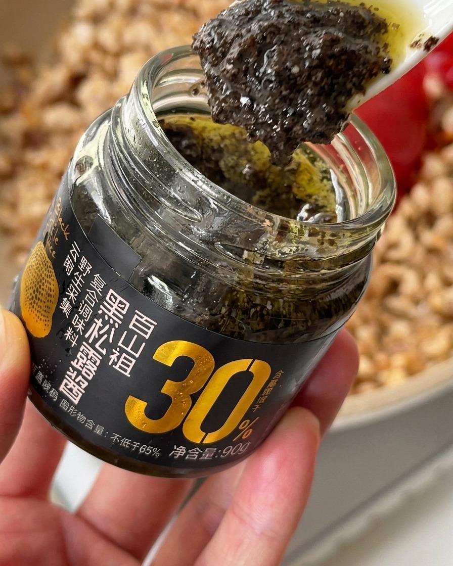 Aggiunta di un cucchiaio di ricca salsa al tartufo nero al pollo condito in padella.