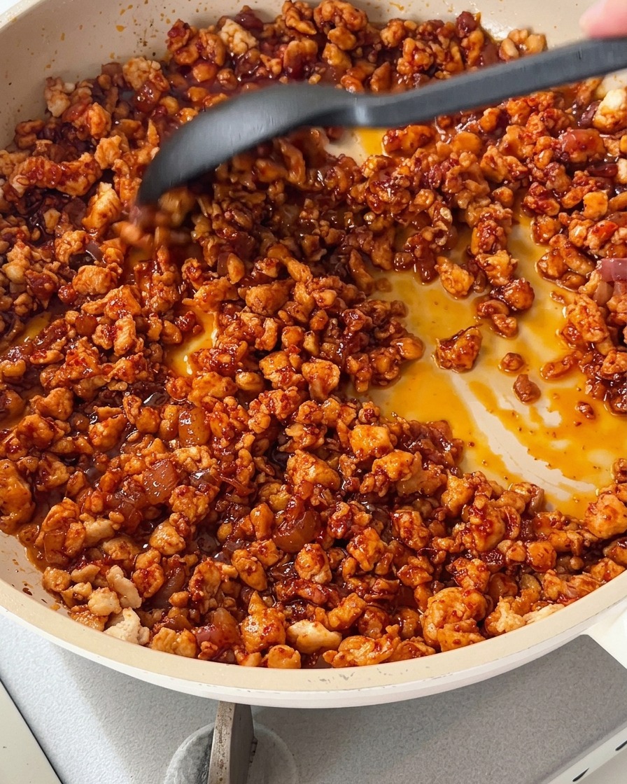Il composto di pollo che cuoce con peperoni a dadini colorati in padella.