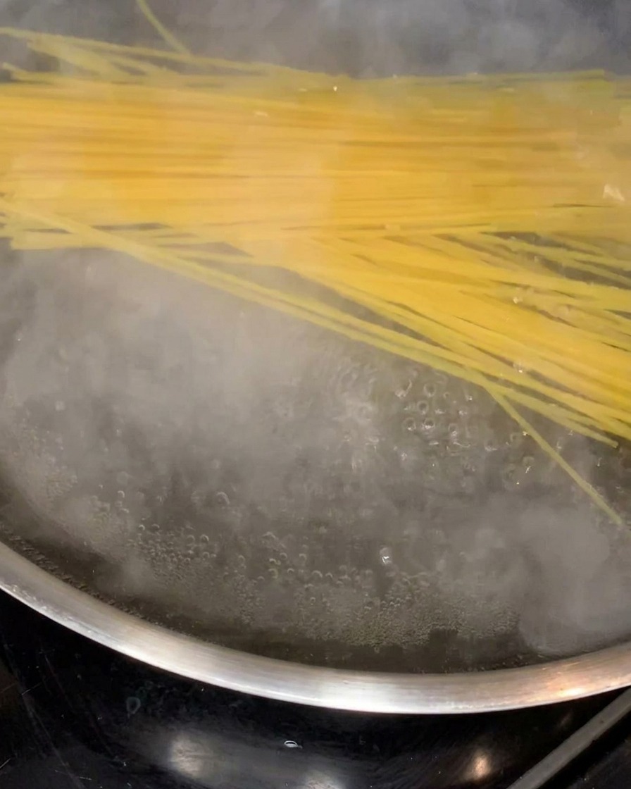 Spaghetti che si ammorbidiscono cuocendo in una pentola dacqua bollente.