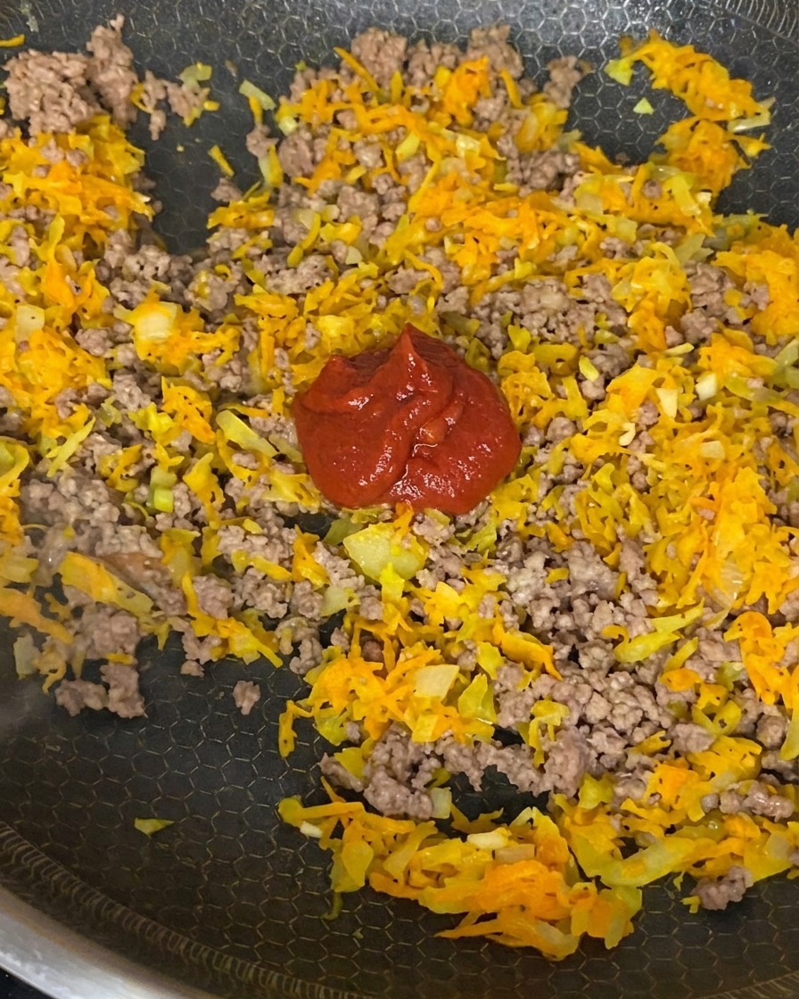 Concentrato di pomodoro, polpa di pomodoro e salsa di soia mescolati con manzo, cipolle e carote.
