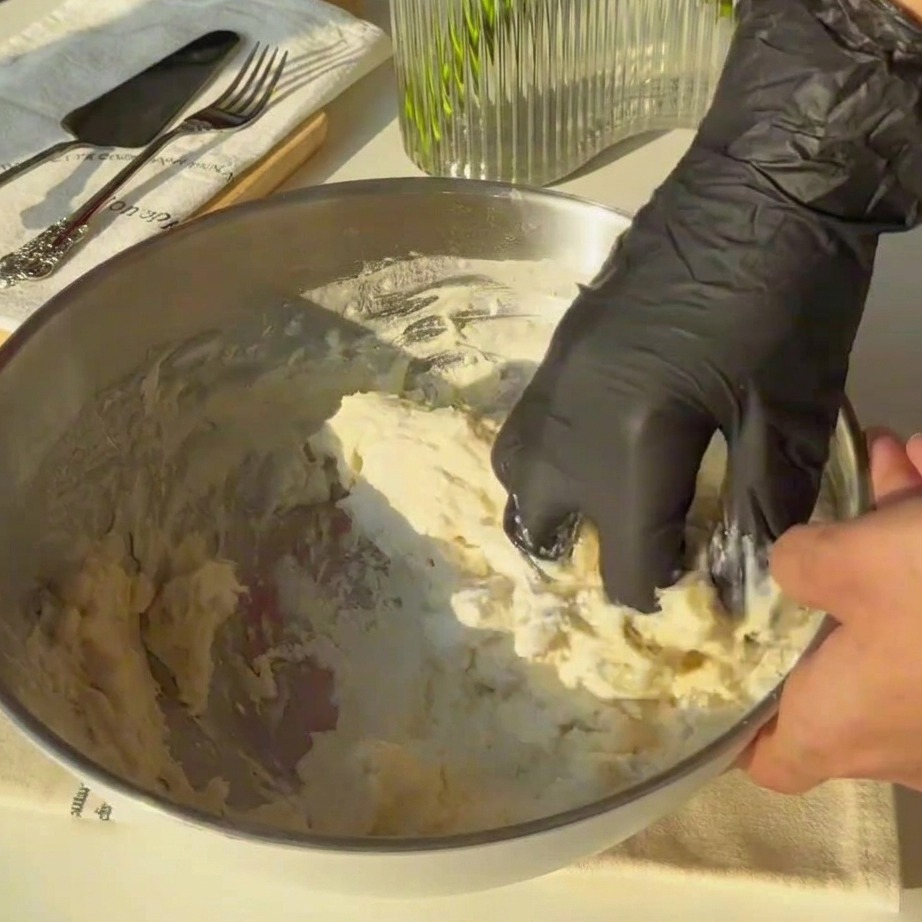 Impasto grezzo lavorato a mano in una ciotola metallica.