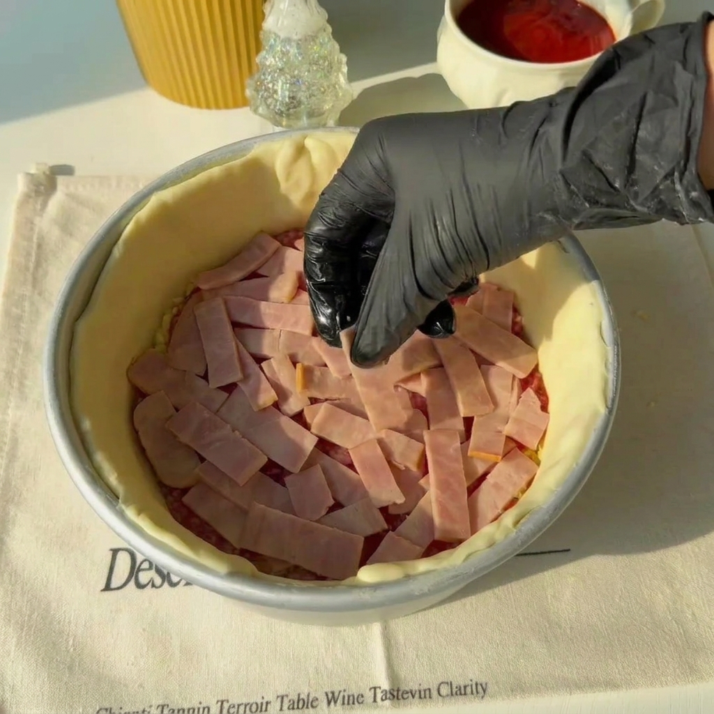 Strisce di pancetta sopra lo strato di salame.