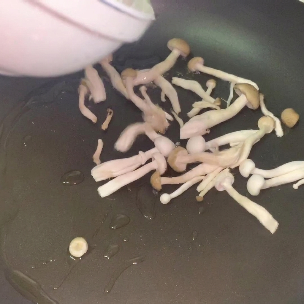 Funghi freschi che saltano in padella con olio caldo fino a doratura.