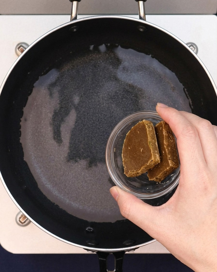 Due blocchi di roux al curry che vengono aggiunti allacqua nella padella.