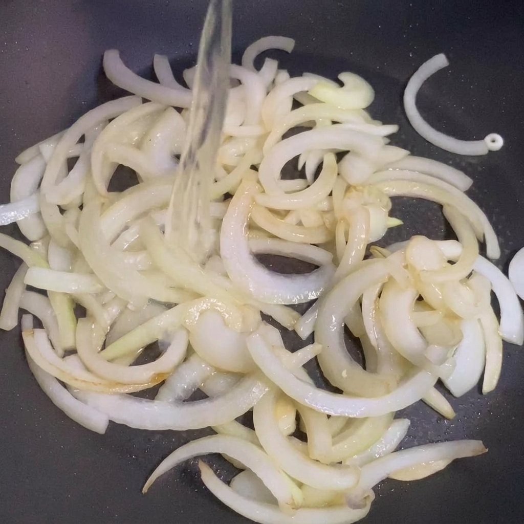 Il sake viene versato in padella insieme alle cipolle soffritte.