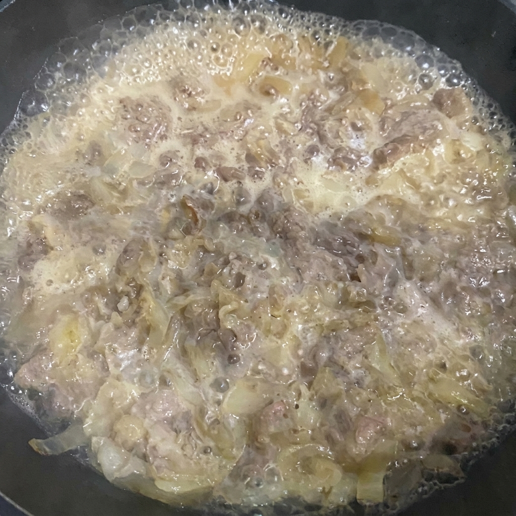 Rimozione della schiuma dal composto di manzo in ebollizione con una spatola.