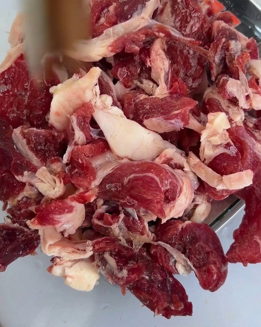 Funghi shiitake affettati freschi adagiati sopra il manzo crudo in una teglia.
