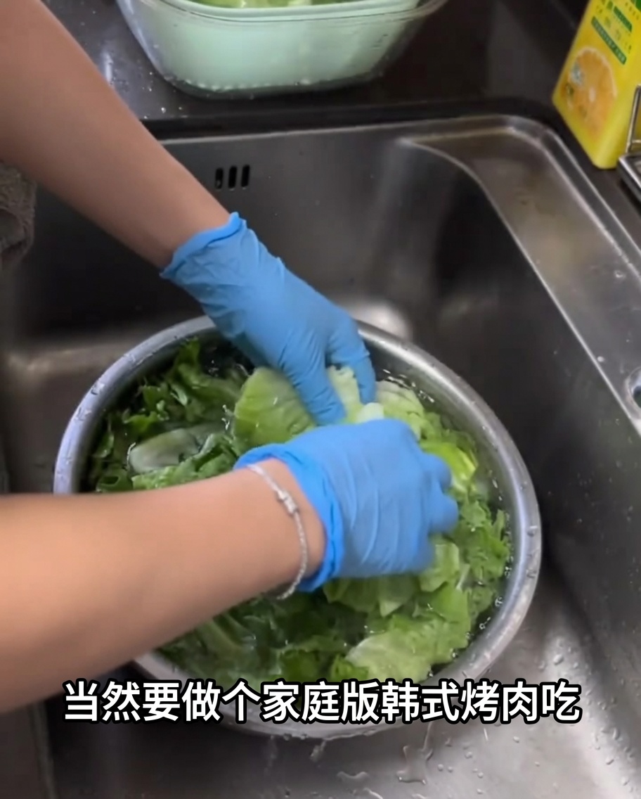 Foglie di lattuga verde fresca lavate in una grande ciotola di metallo piena dacqua.