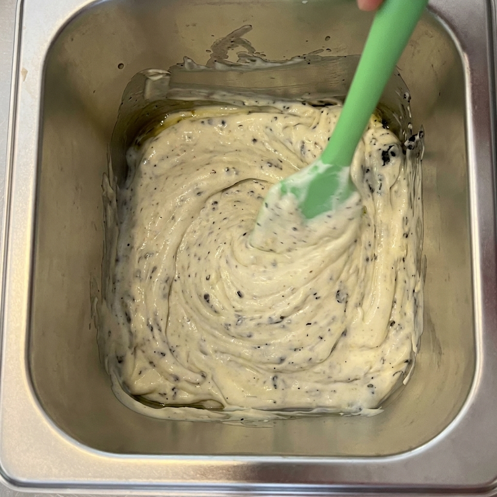 Tartufo nero, maionese e olio doliva miscelati in un contenitore di metallo.