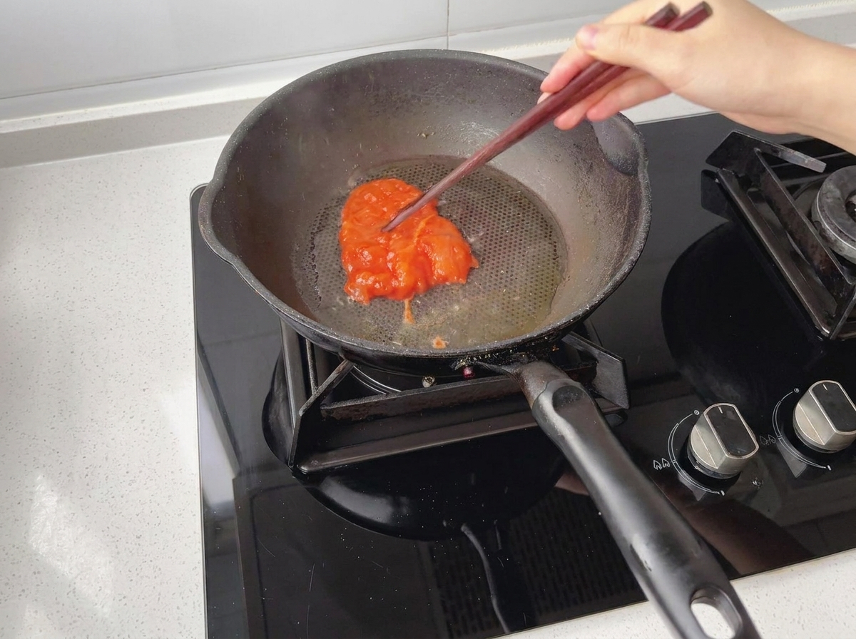 Pezzi di pollo marinato posizionati in una padella preriscaldata e oliata.