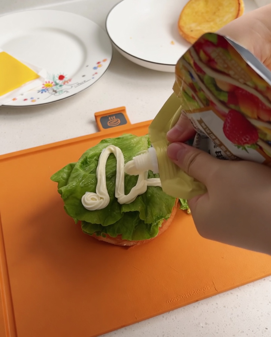 Salsa bianca spremuta da un sacchetto su una foglia di lattuga.