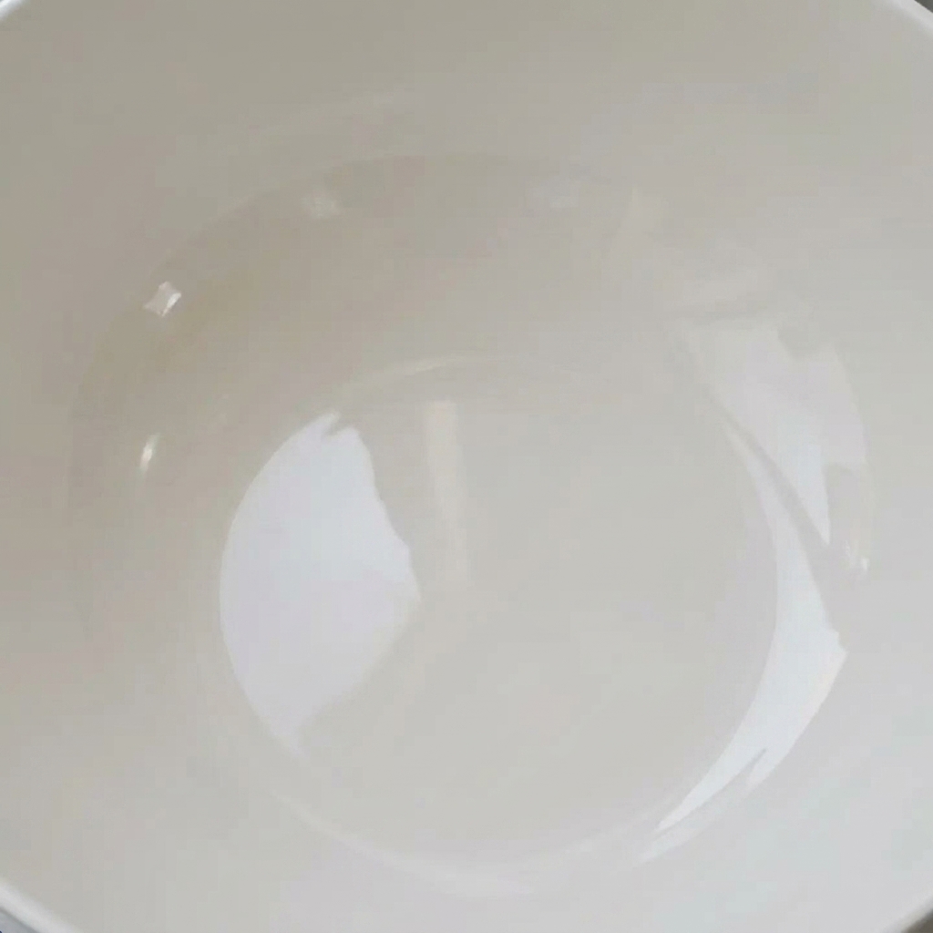 Vongole fresche a bagno in una ciotola bianca con acqua limpida, pronte per essere spurgate.