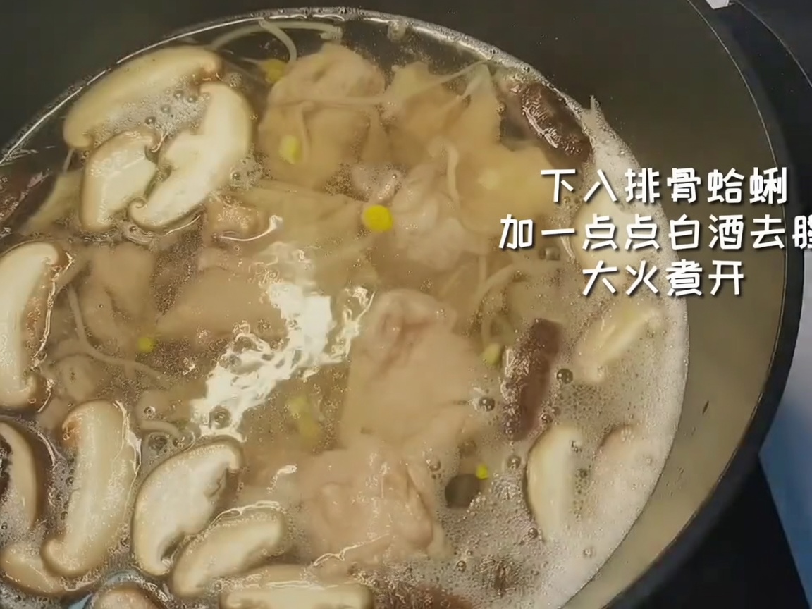 Costine di maiale sbollentate e vongole pulite aggiunte in una pentola con verdure e acqua bollente.